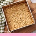 Pinterest graphic of a parchment lined baking pan with uncut flapjacks on a serving board with a bowl of berries beside it.