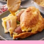 Pinterest graphic of a spoon pouring gravy over toad in the hole on a plate. Another serving in the background.
