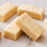Multiple pieces of shortbread biscuits with one leaning on top of another.